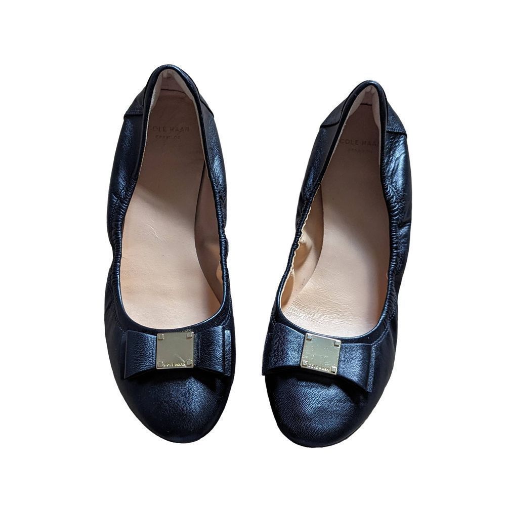 Cole Haan grand OS black flats with a gold label buckle in front size 9AA